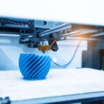 A 3D printer creating a blue vase
